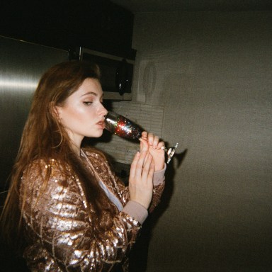 girl in gold jacket drinking champagne