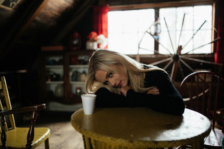 blonde girl in a cabin drinking coffee