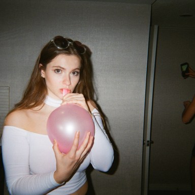 woman blowing up balloon