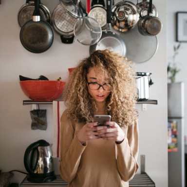 Fascinated girl in kitchen reading an article on a website