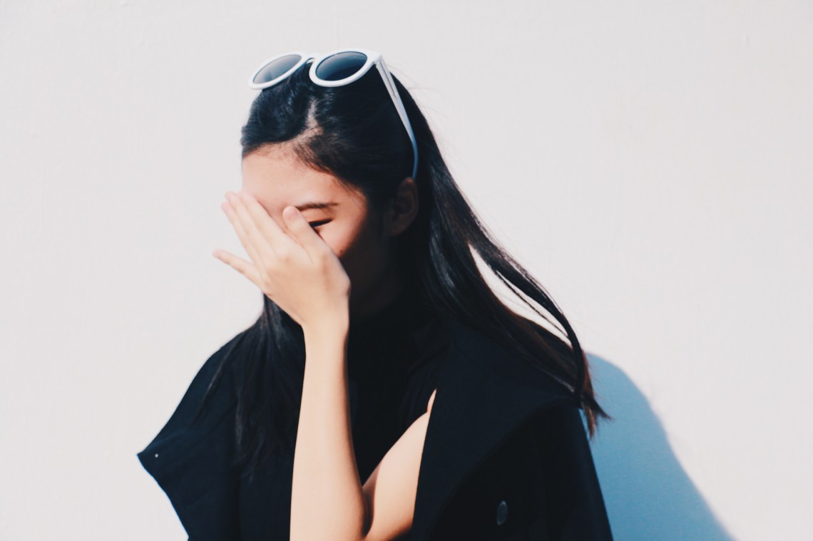Woman covers her face with her hand out of embarrassment