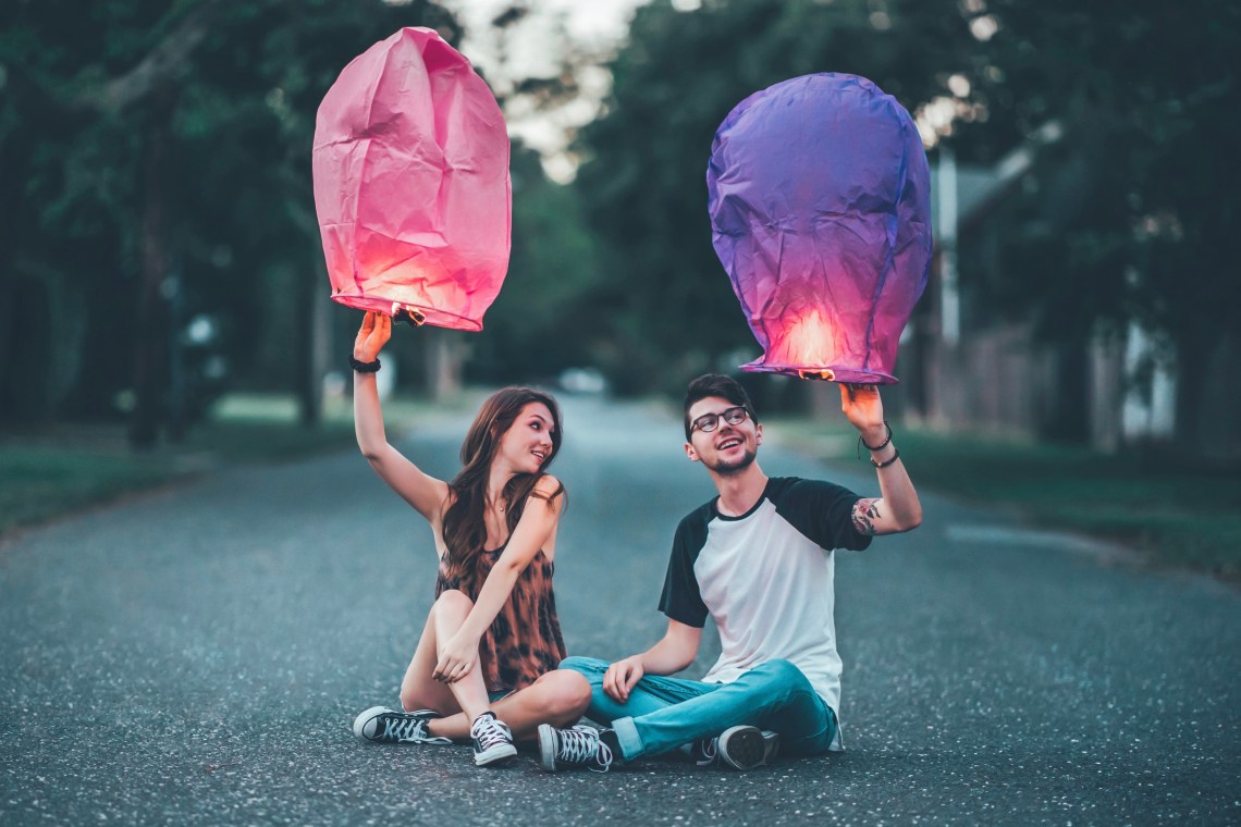 couple sitting with lanterns in street