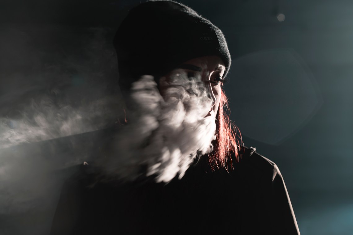 girl red hair smoke in her face