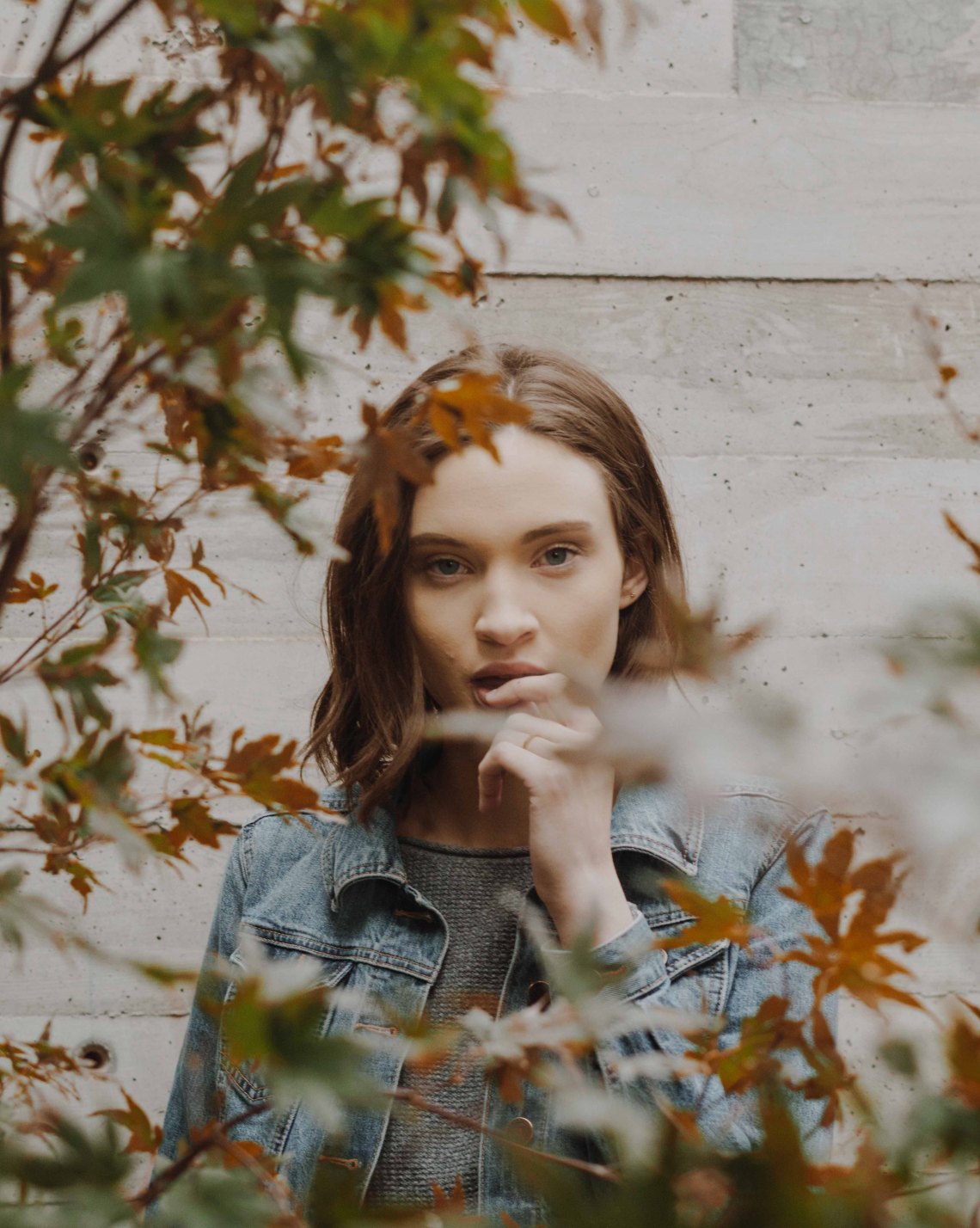 Woman peering from behind the leaves