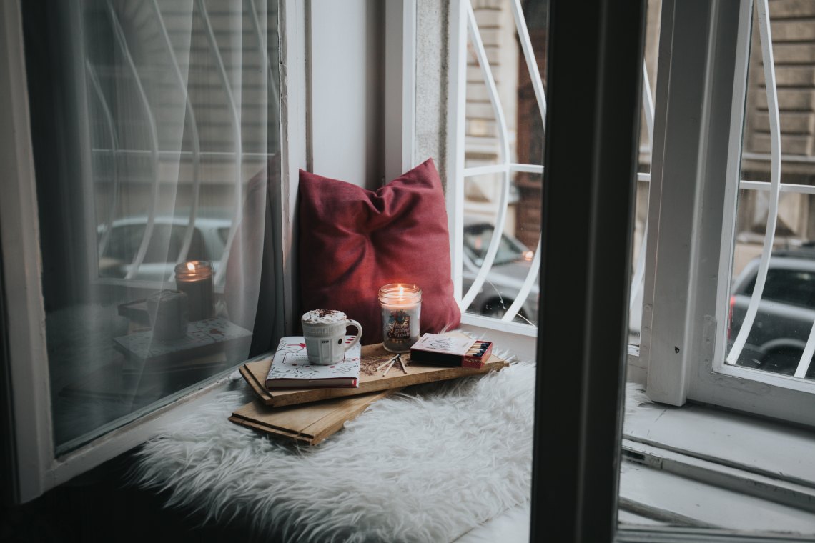 candle, hot chocolate on window seat