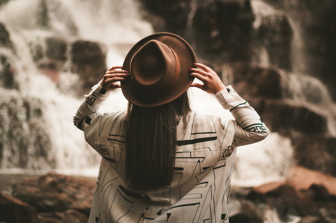 girl with a hat and a waterfall