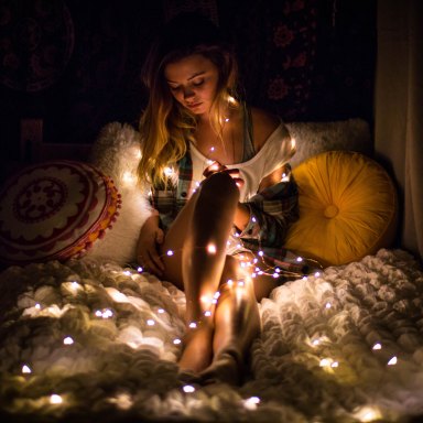 woman wrapped in christmas lights