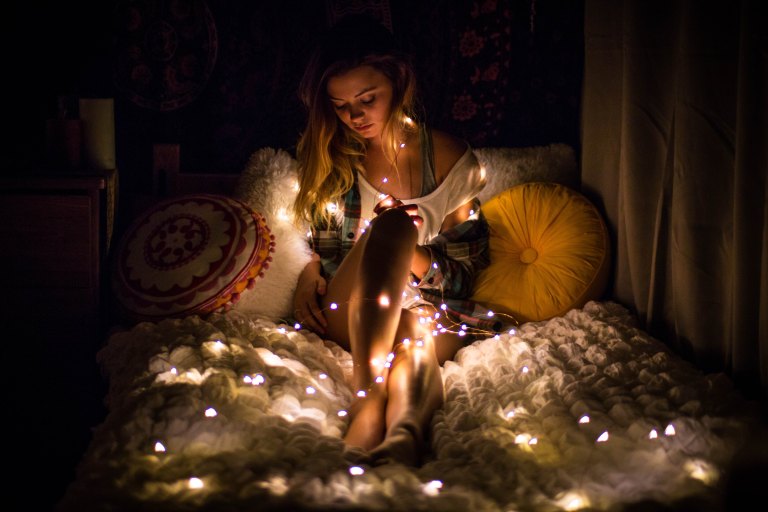 woman wrapped in christmas lights
