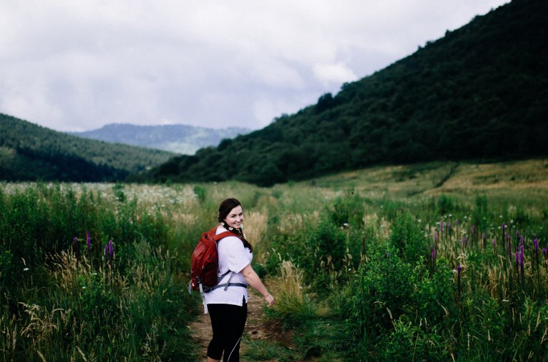 girl hiking in a pretty field