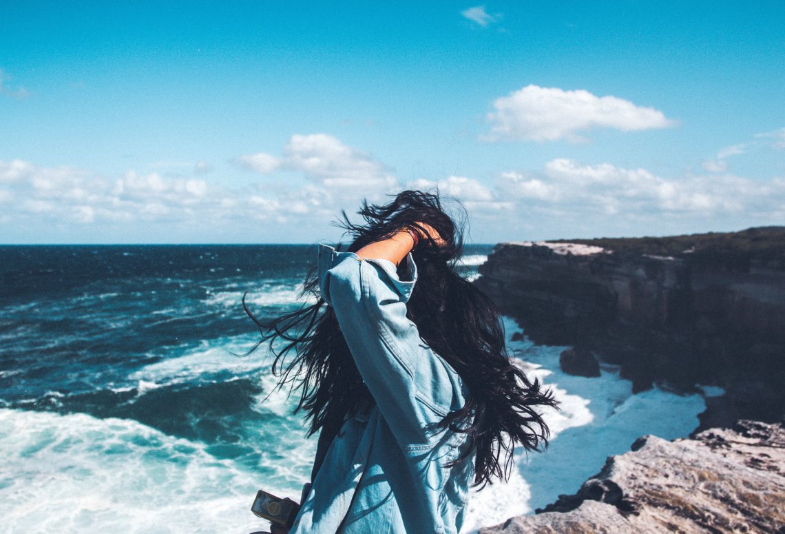 woman by the sea with windy hair