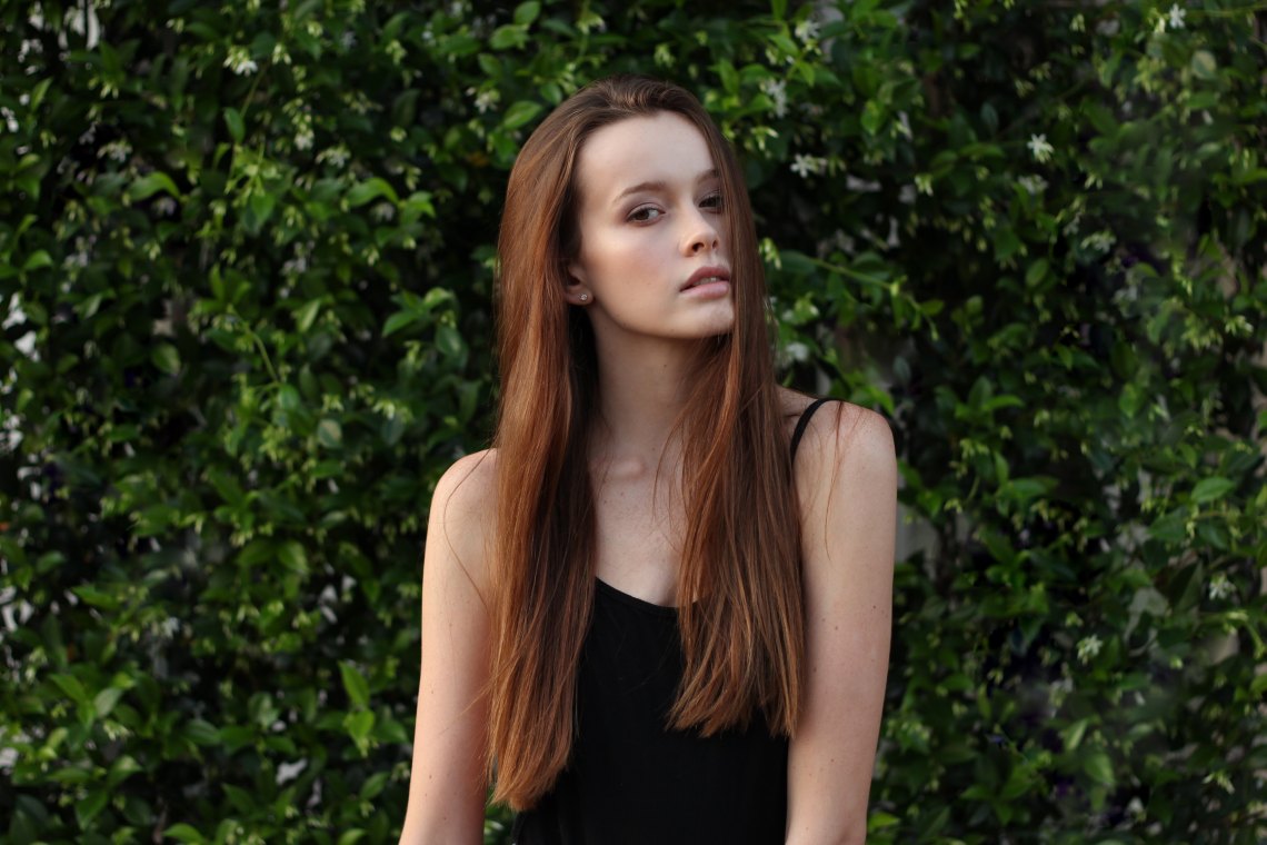 woman standing in front of bushes