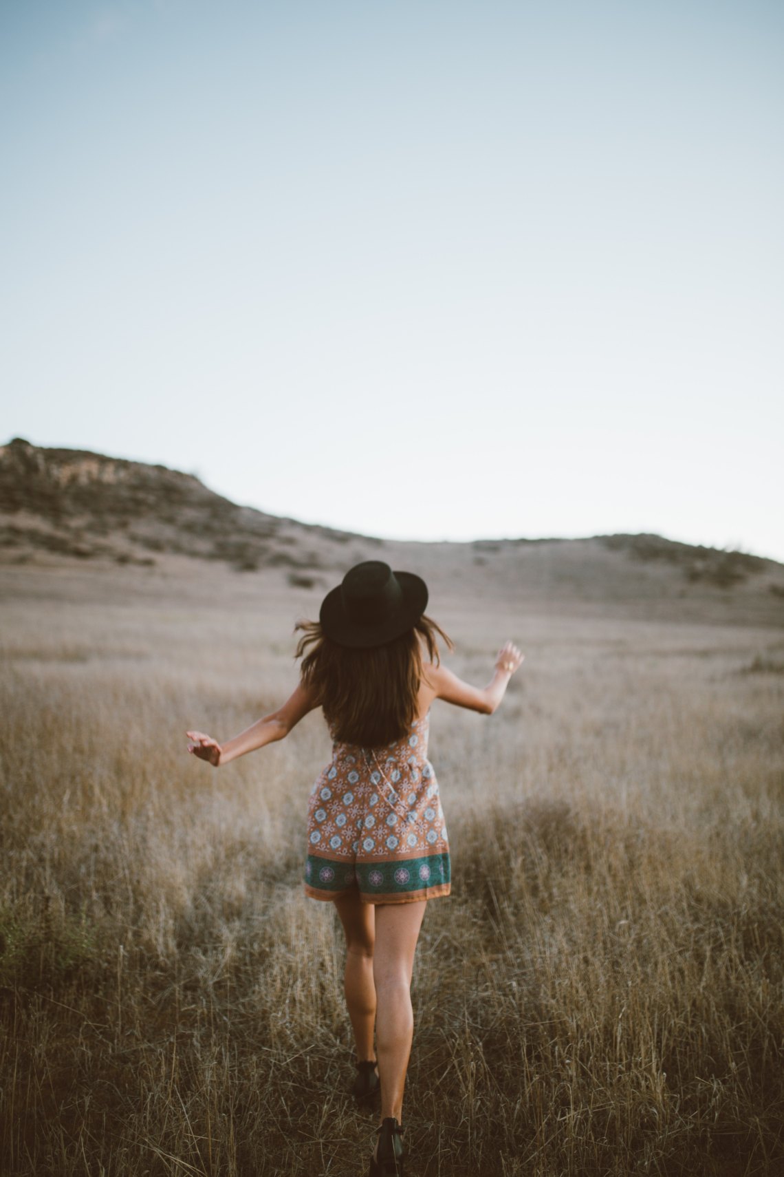 woman walking away in field