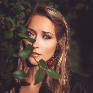 girl standing behind tree
