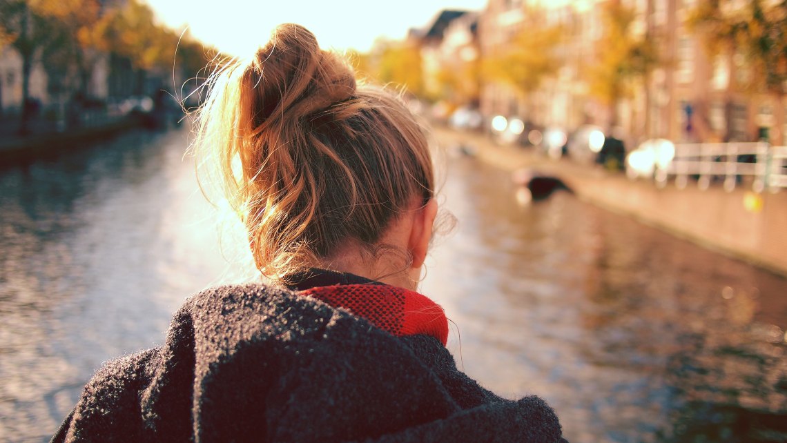 back of woman's head in front of a river