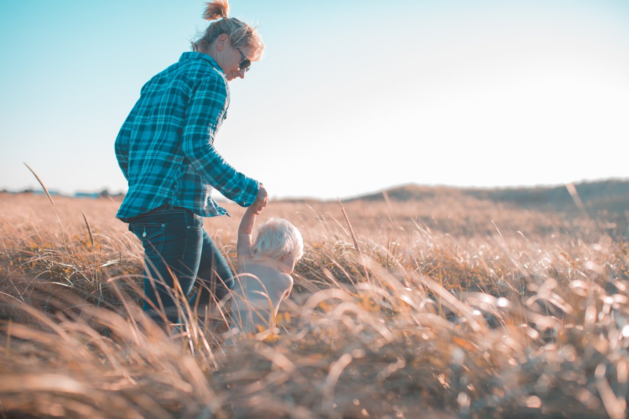 Mom and kiddo running through a wheat field