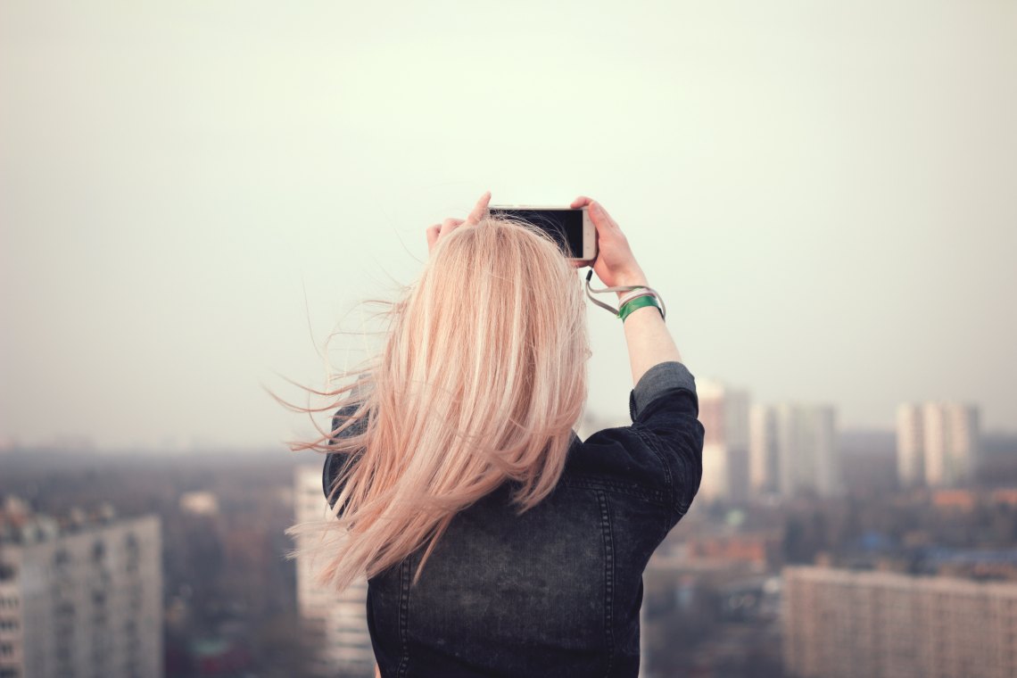 girl with pink hair taking a picture