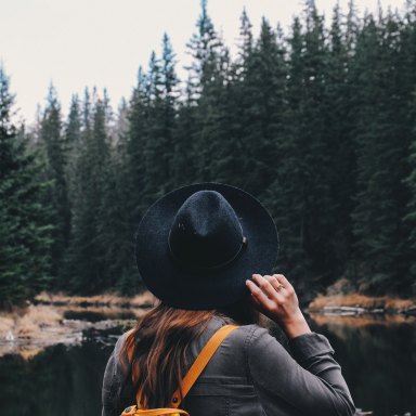 woman wandering through the forest in her hat