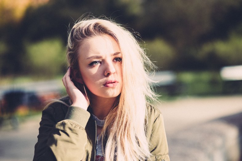 blonde woman pushing her hair back
