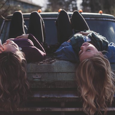 friends laying on a car