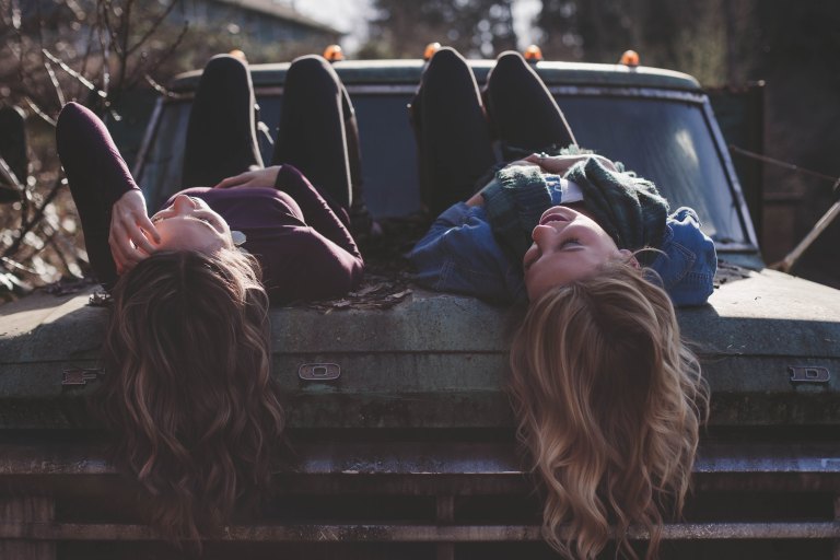 friends laying on a car