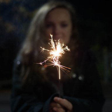 girl holding a sparkler backlit