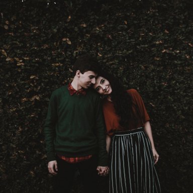Couple holding hands in greenery