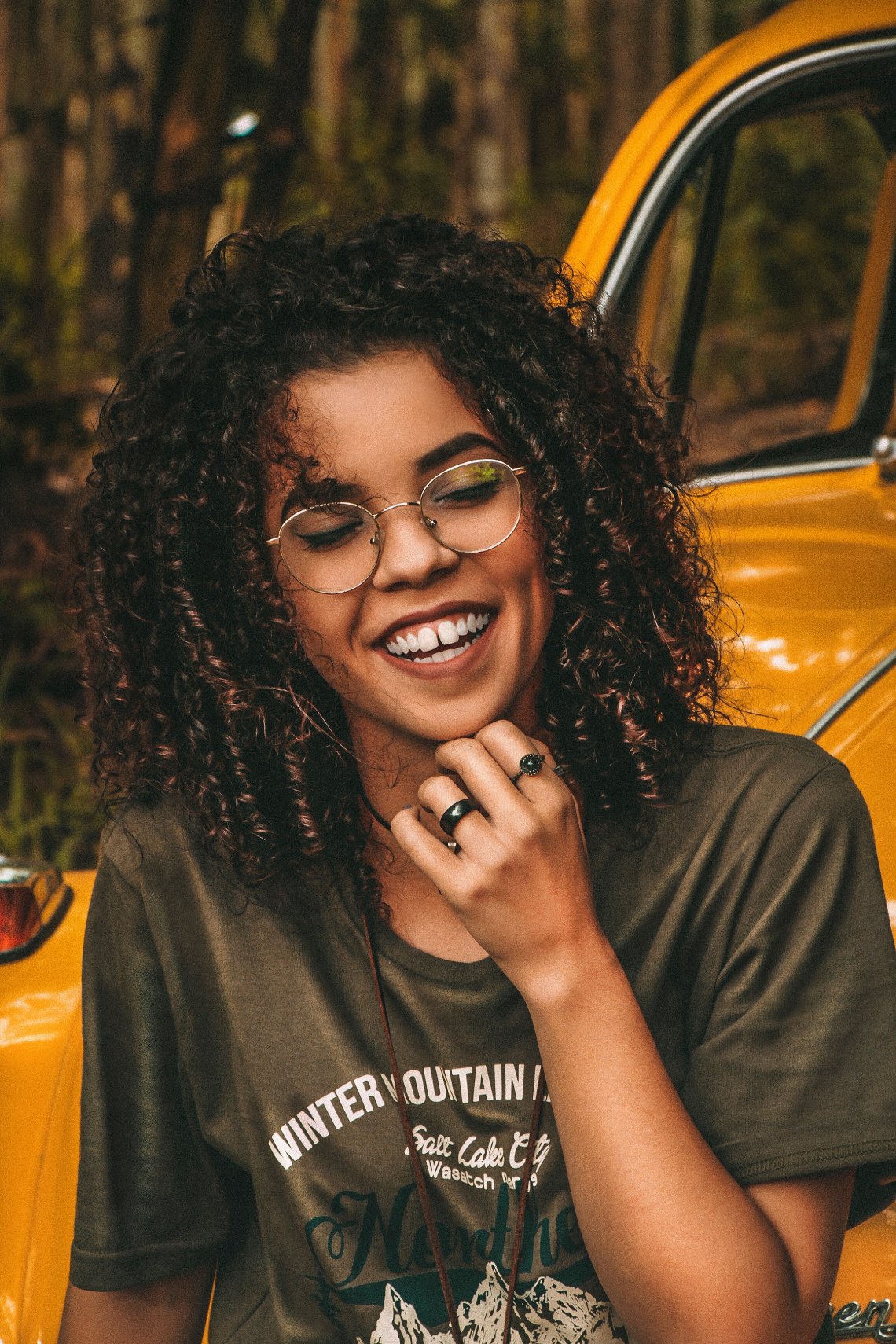 woman laughing on a yellow car