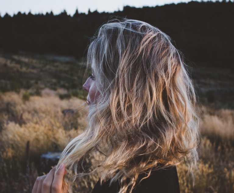 girl looking out at field, blonde, calm expression, brokenness, romanticizing brokenness, fear of feeling good