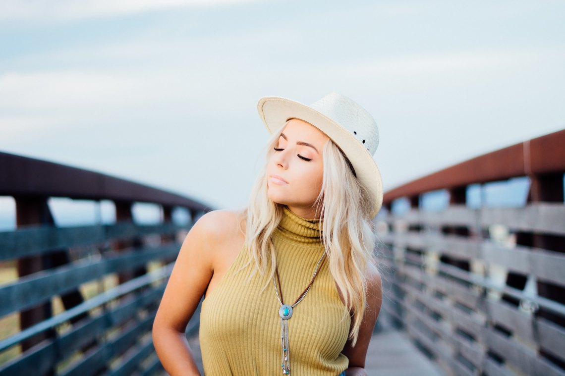 girl eyes close on a dock wearing a hat