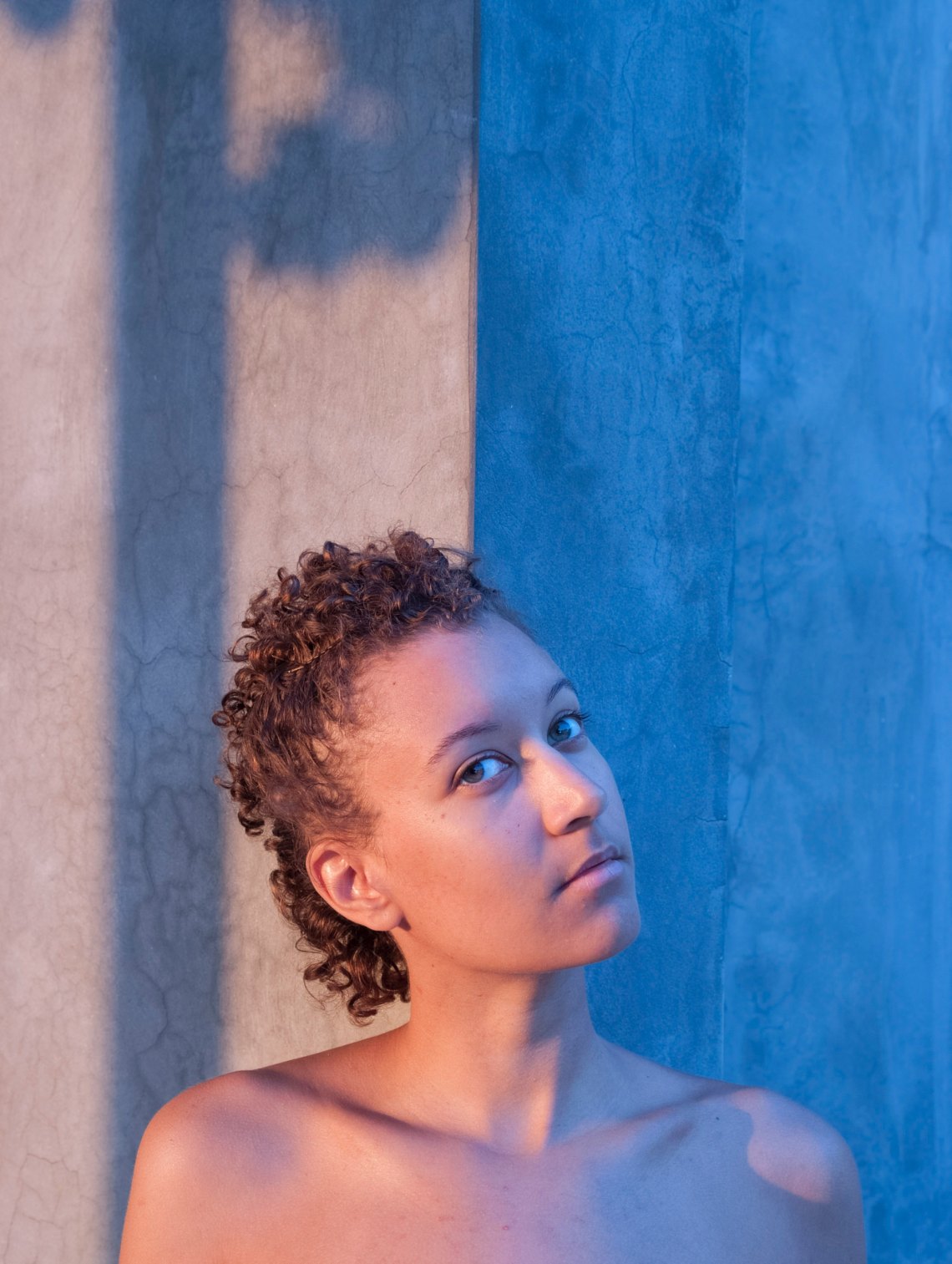 girl next to a blue wall