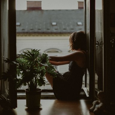 woman sitting looking outside of window