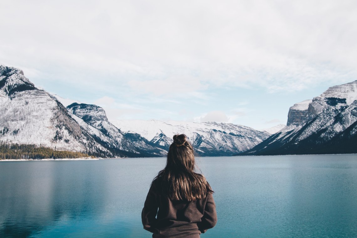 girl standing in front of a lake