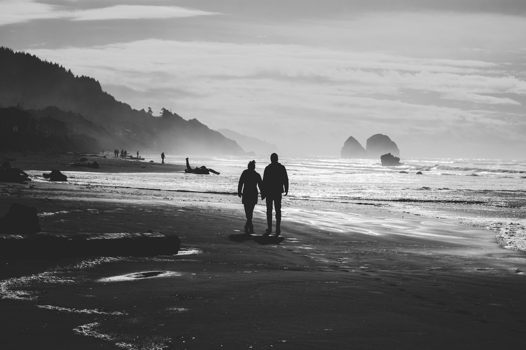 Hearty view of a couple holding hands and enjoying a walk on the beach