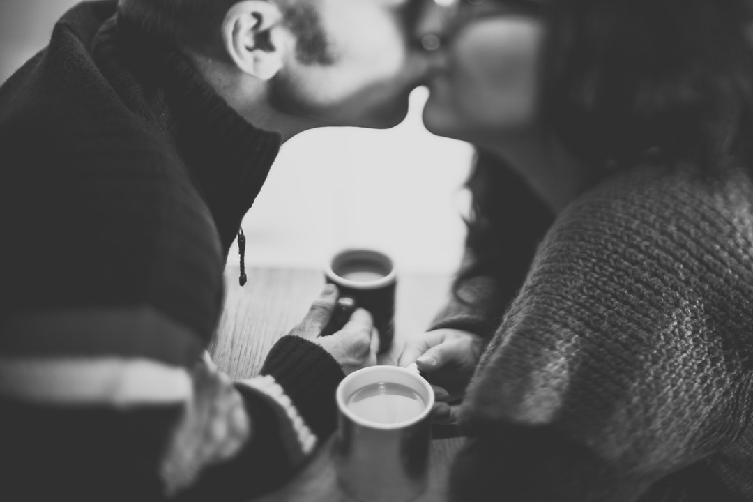 A couple kiss in this fuzzy black and white shot of coffee