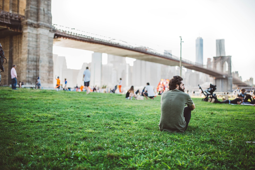 People relaxing on a lawn near the Brooklyn Bridge