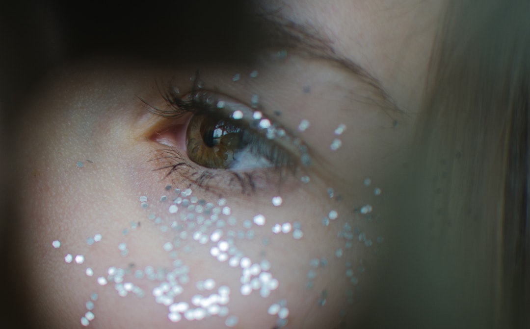 Close-up of glitter around a woman's eye
