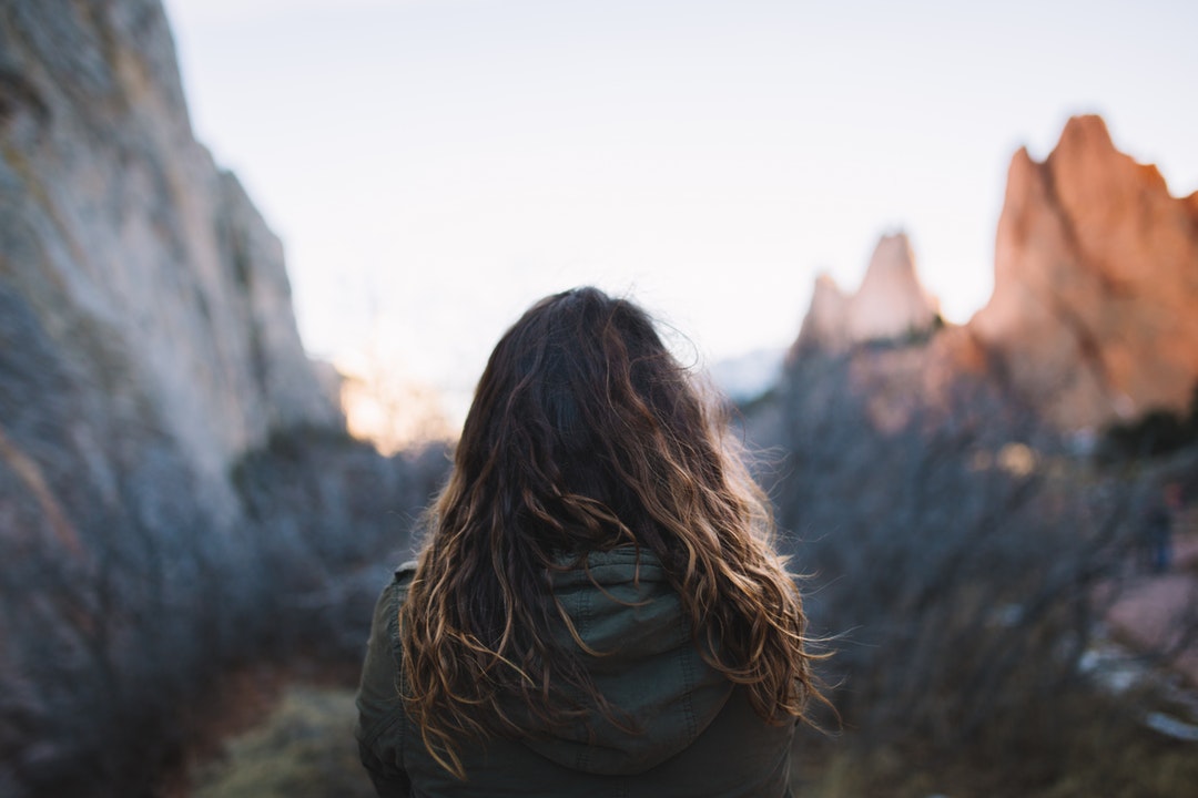 Woman with wavy hair exploring the mountains on a hike alone