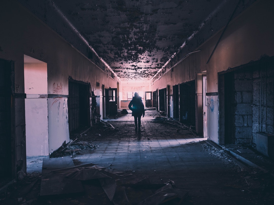 A person walking inside a dimly lit Detroit building at night