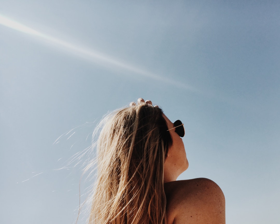 A woman in sunglasses looking at the sky