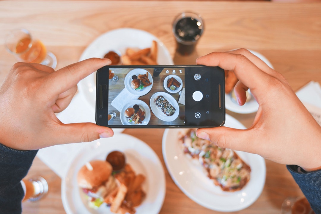 Person takes a picture of their brunch on their smartphone