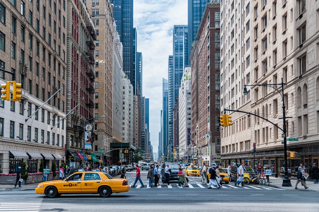Ground view of New York City skyscrapers from a busy street intersection