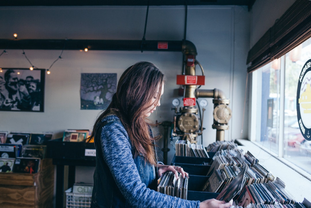 A woman browsing vinyl records in a record store