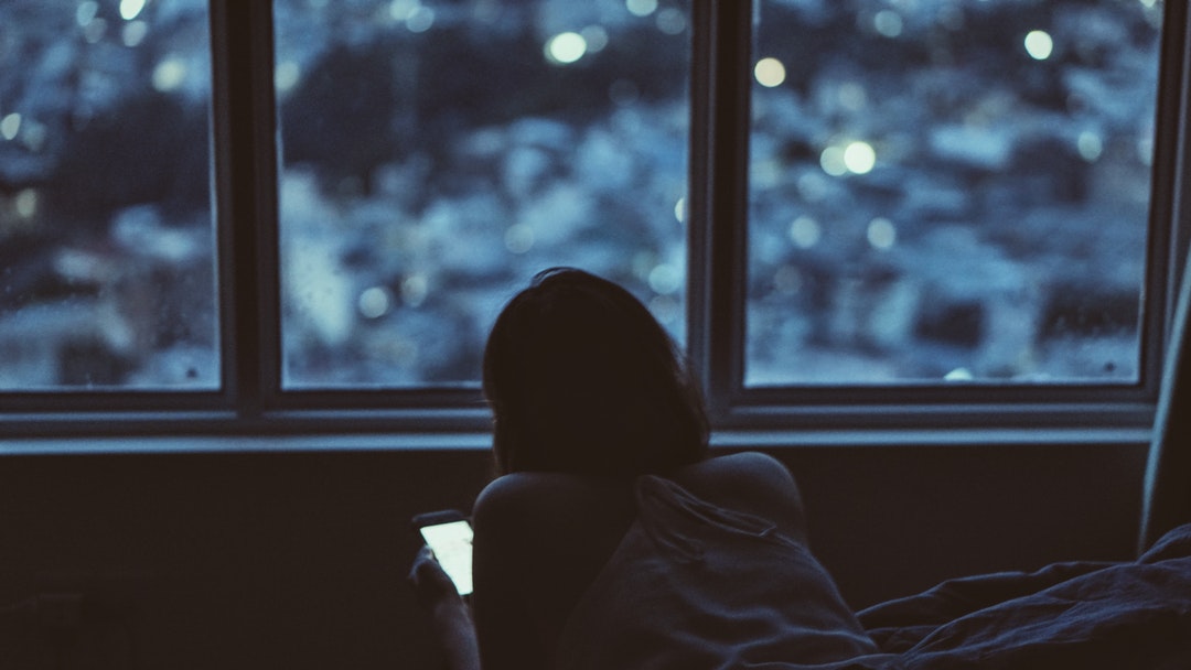 A girl staring at her phone from inside her Ho Chi Minh City home