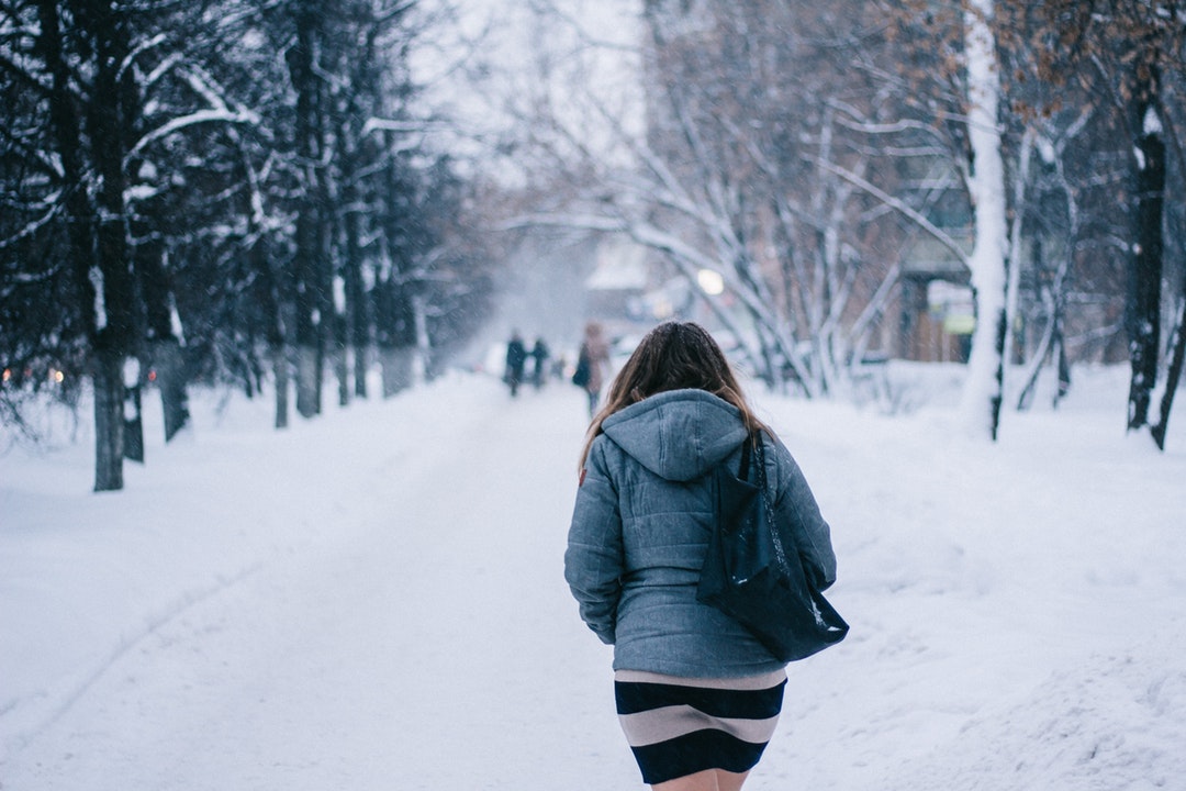 woman walking on street during winter