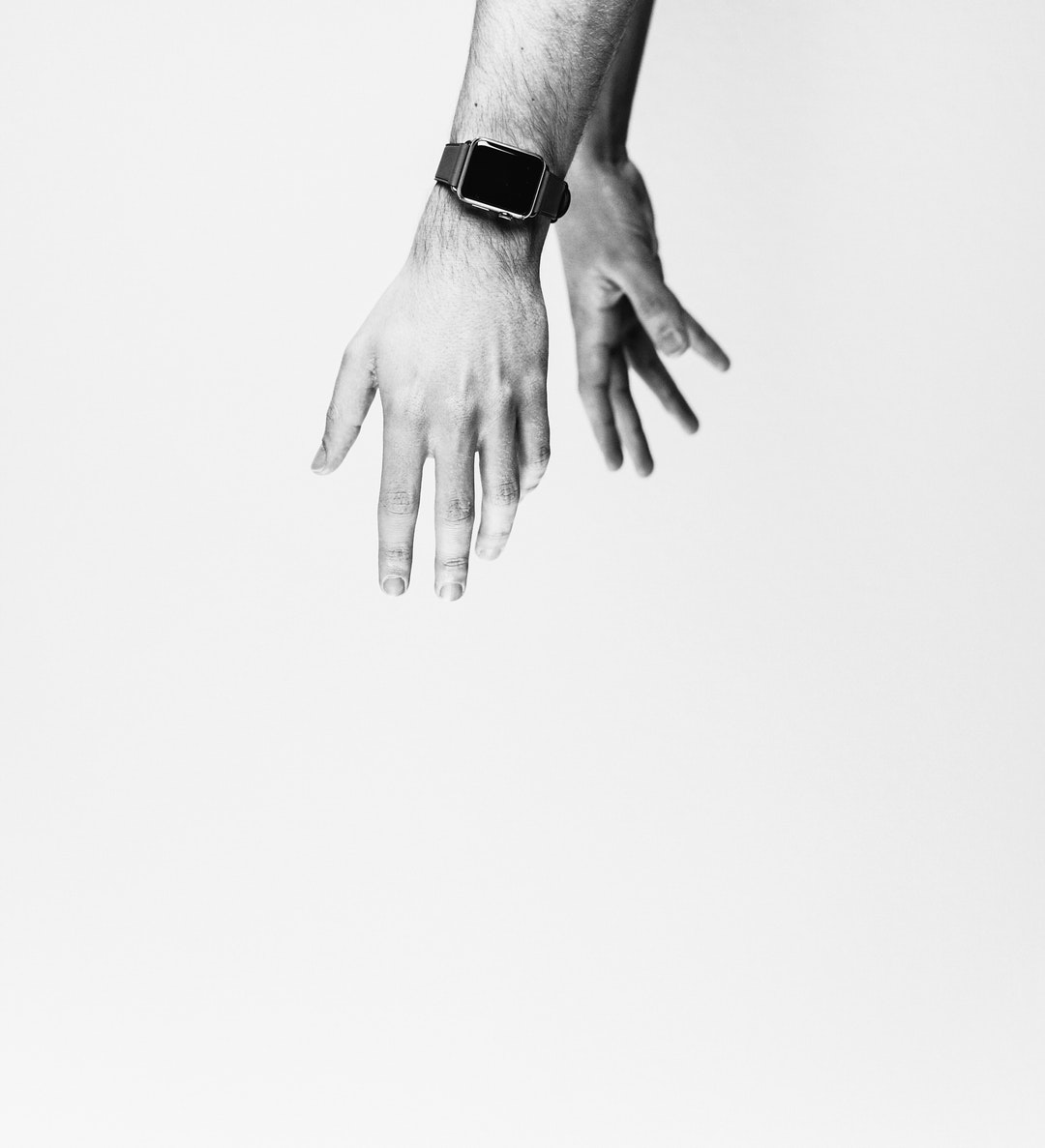 The hands of a person wearing an Apple Watch in black and white