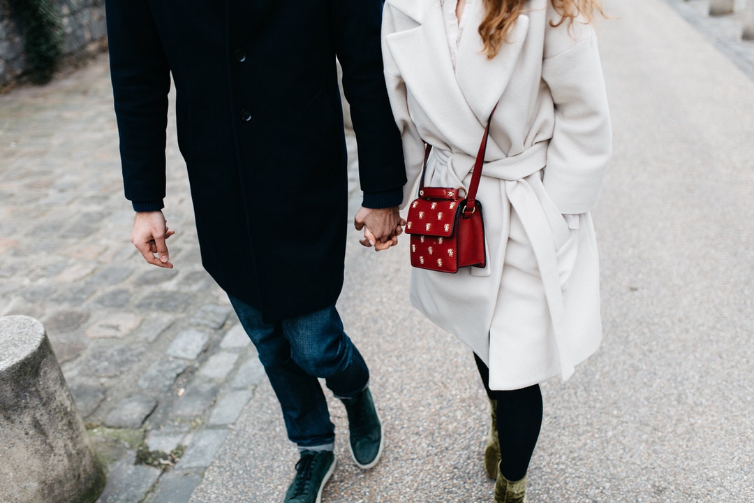 couple holding hands while walking