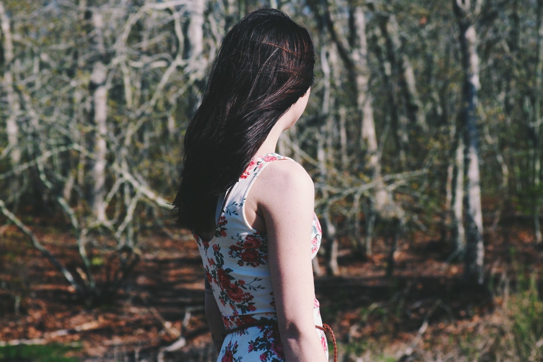 woman looking towards forest during daytime