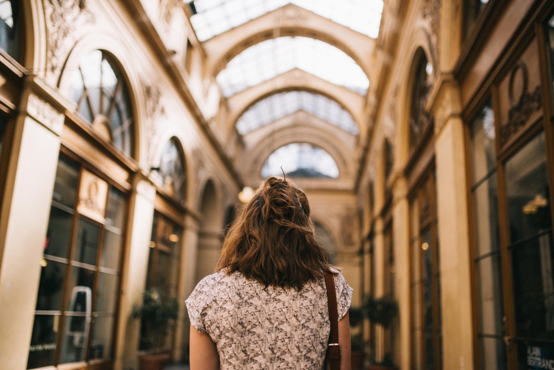A fashionable young woman in a tunnel with a glass ceiling