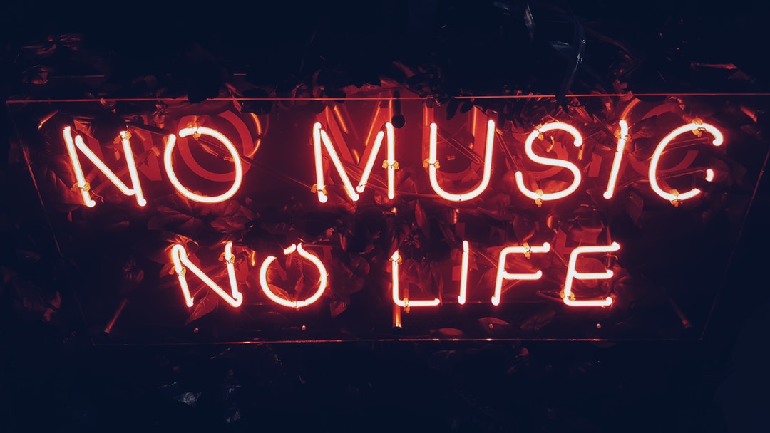A red neon reads “No music, no life” against a dark background