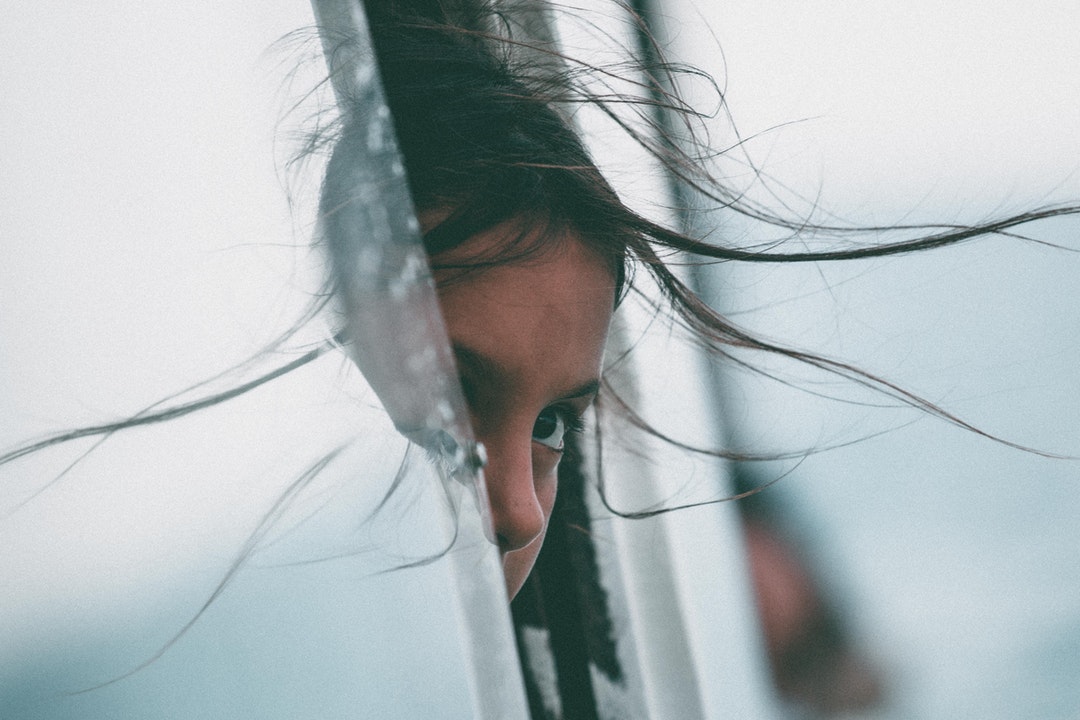 Young girl curiously peeking out of a vehicle window at Cinque Terre Point